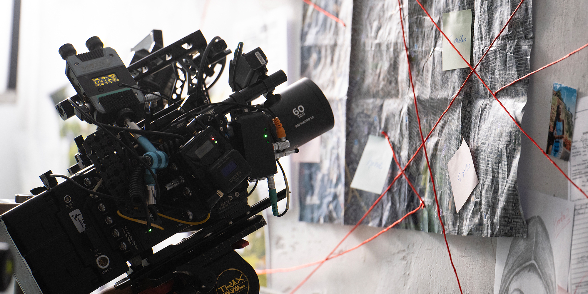 width=100% Obiektyw Laowa Nanomorph 60 mm T2,9 1,5x S35 Macro 1:2 Amber do Arri PL/Canon EF zainstalowany na kamerze skierowany na tablicę z karteczkami i notatkami